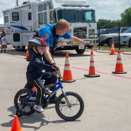 Officer helping a kid on his bike